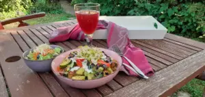 Das Bild zeigt einen gedeckten Gartentisch mit Essen